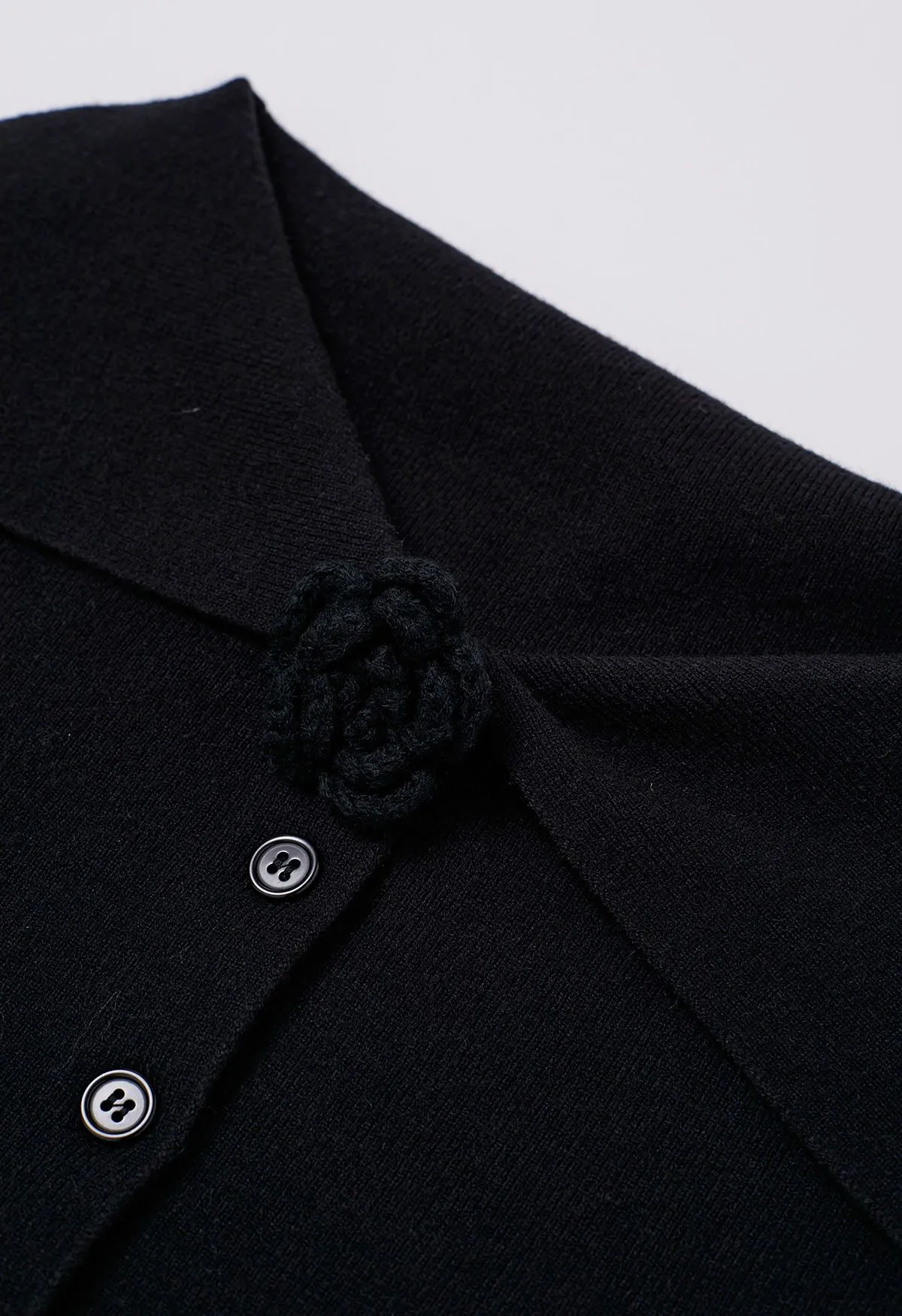 Schulterfreies Stricktop mit Knopfleiste und Blumenbrosche in Schwarz